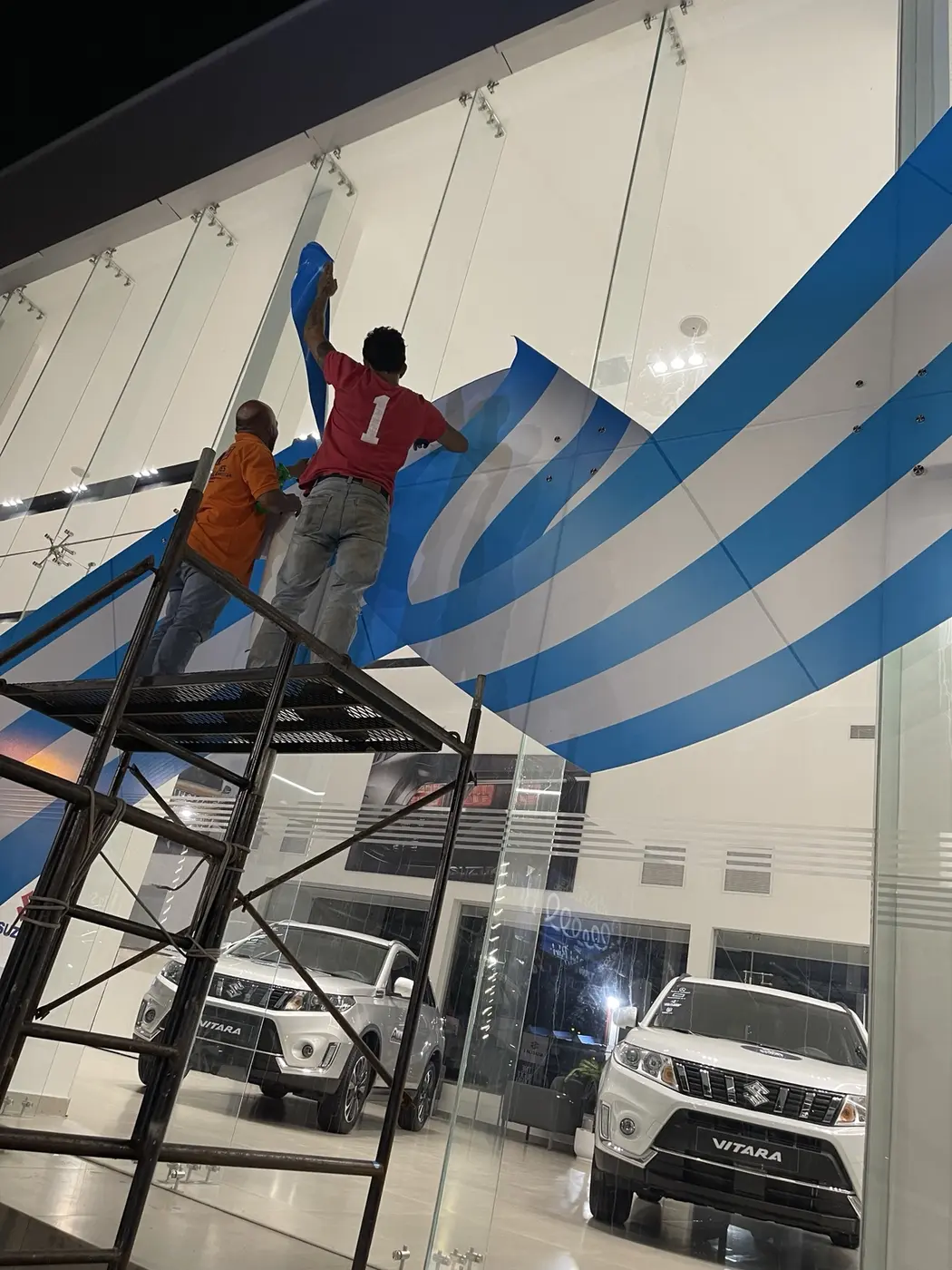 Equipo instalando gráfica Suzuki en altura